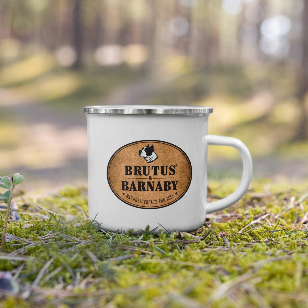 White enamel mug with Brutus & Barnaby logo, featuring natural dog treats branding, set on mossy forest ground.